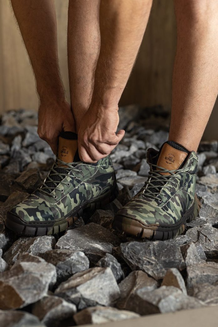 pexels-photo-8159367 a person fixing his hiking shoes he is wearing