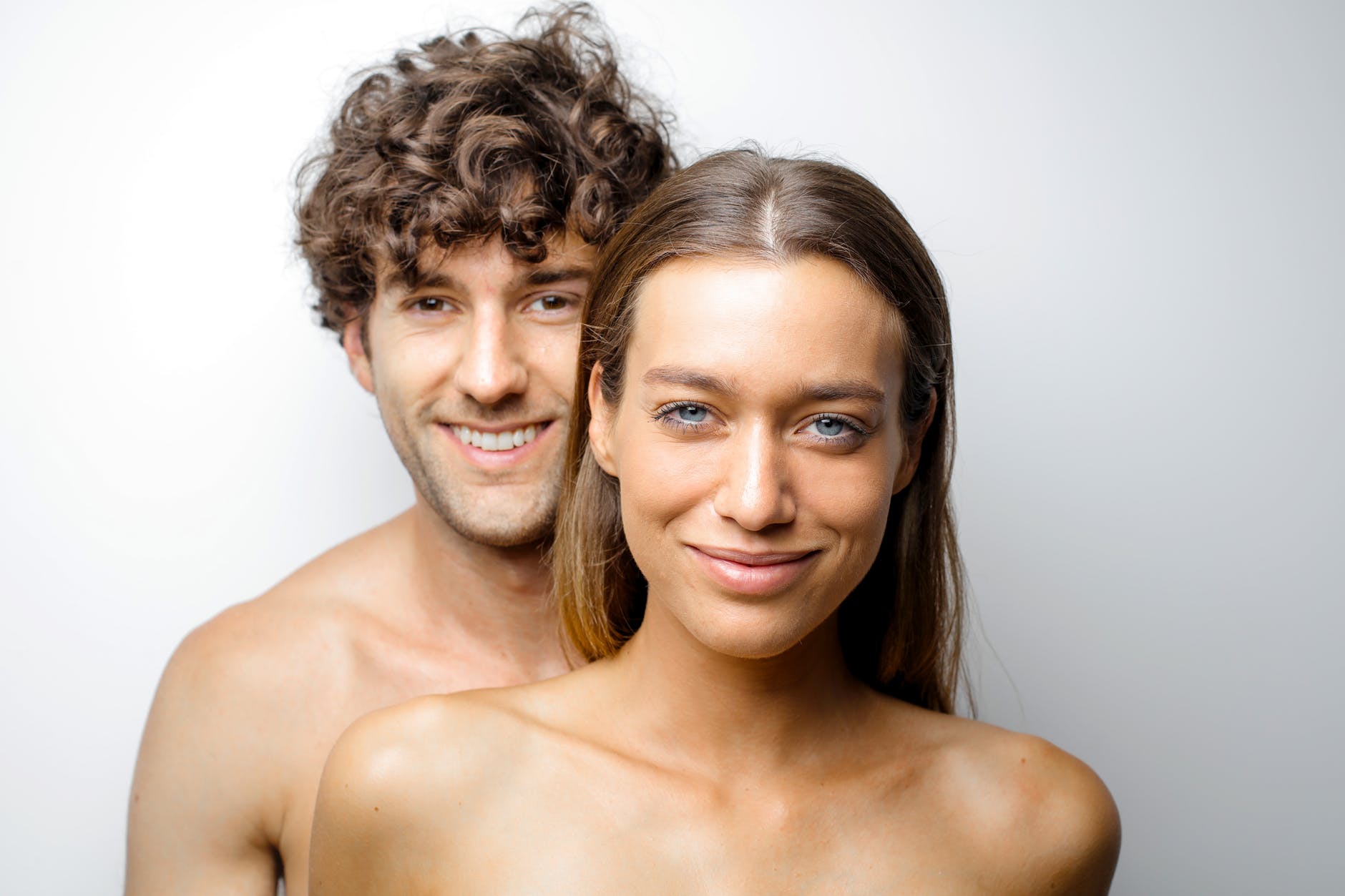 topless woman beside smiling man