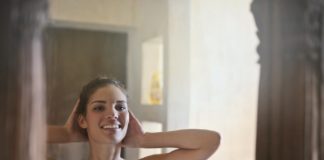 happy woman looking at mirror in bathroom