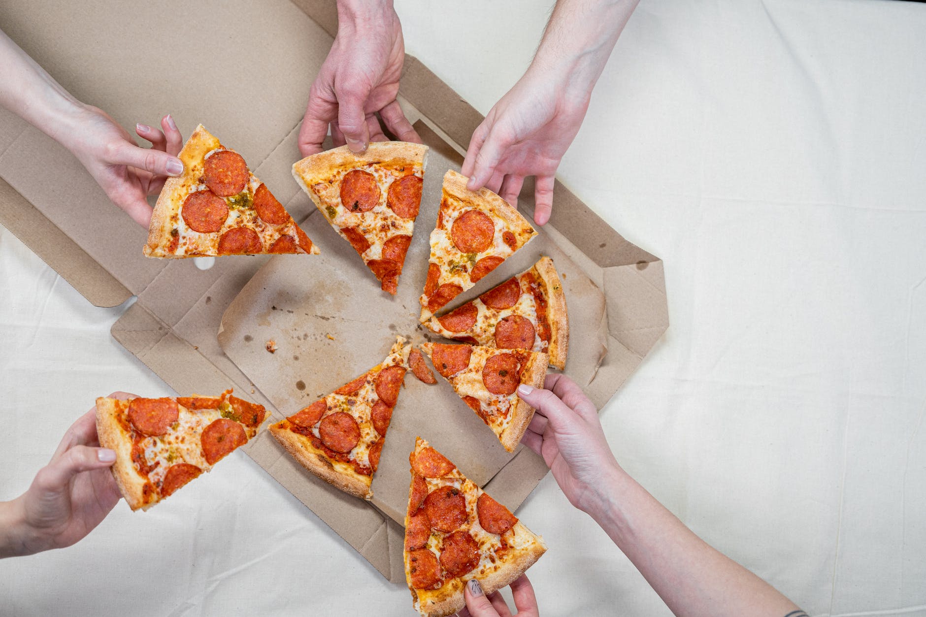 photo of people holding pizza