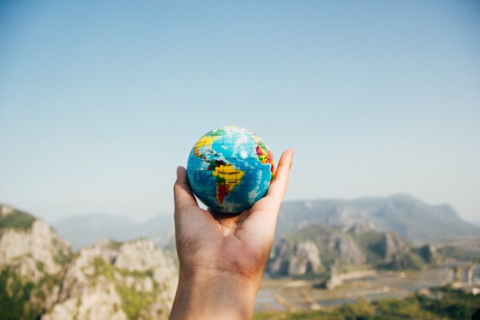 pexels-photo-346885 person holding world globe facing mountain