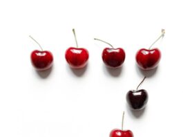 photo of ripe cherries on white surface