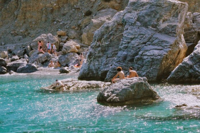 photo of people on the rocky beach